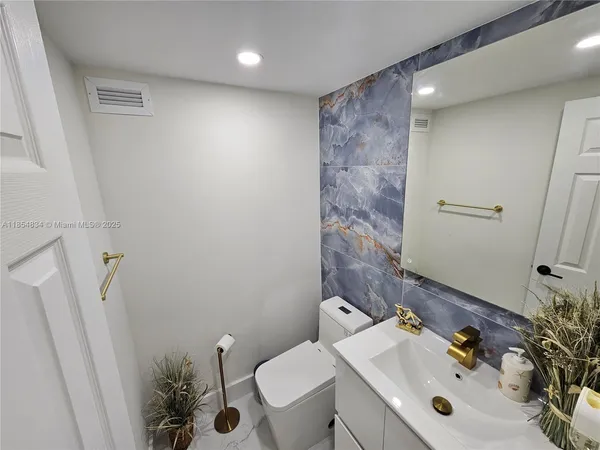 a bathroom with a sink mirror and toilet