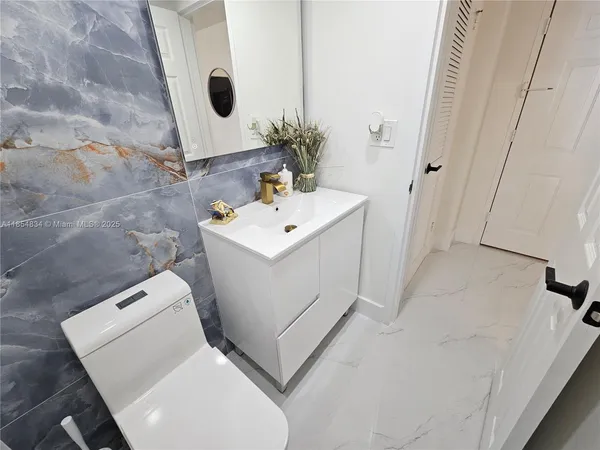 a bathroom with a sink toilet and mirror