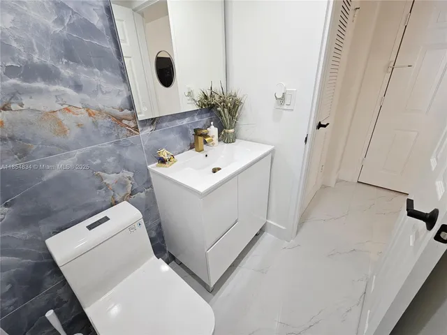 a bathroom with a sink toilet and mirror