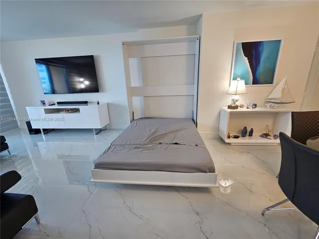 a bedroom with a bed and flat screen tv