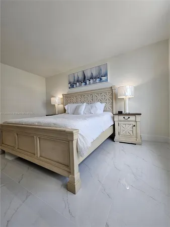 a bedroom with a bed and a lamp on the dresser