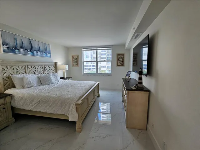 a bedroom with a bed a couch and dresser