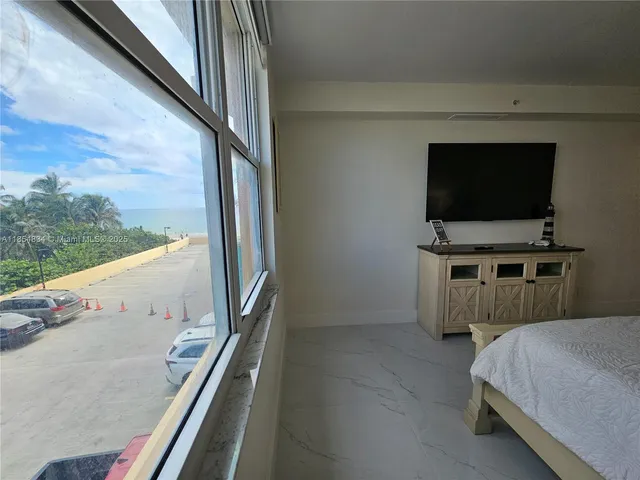 a living room with a flat screen tv on dresser and a wooden floor