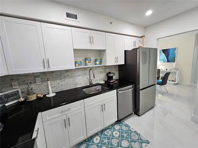 a kitchen with stainless steel appliances a refrigerator sink and cabinets