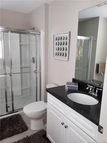a bathroom with a granite countertop sink toilet and shower