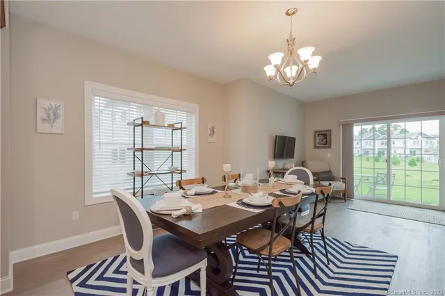a view of a dining room with furniture a chandelier and wooden floor
