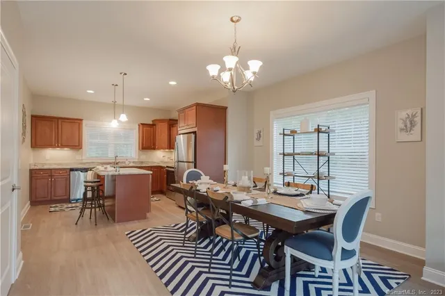 a view of a dining room with furniture a chandelier and wooden floor