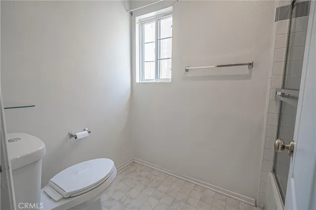 a white toilet sitting next to a window