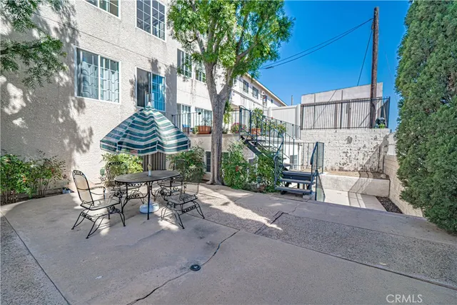 a view of a patio with table and chairs and potted plants