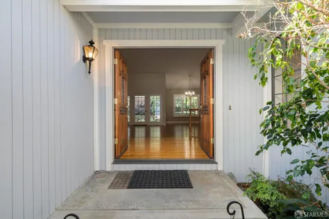 a view of a hallway with wooden floor and dining room