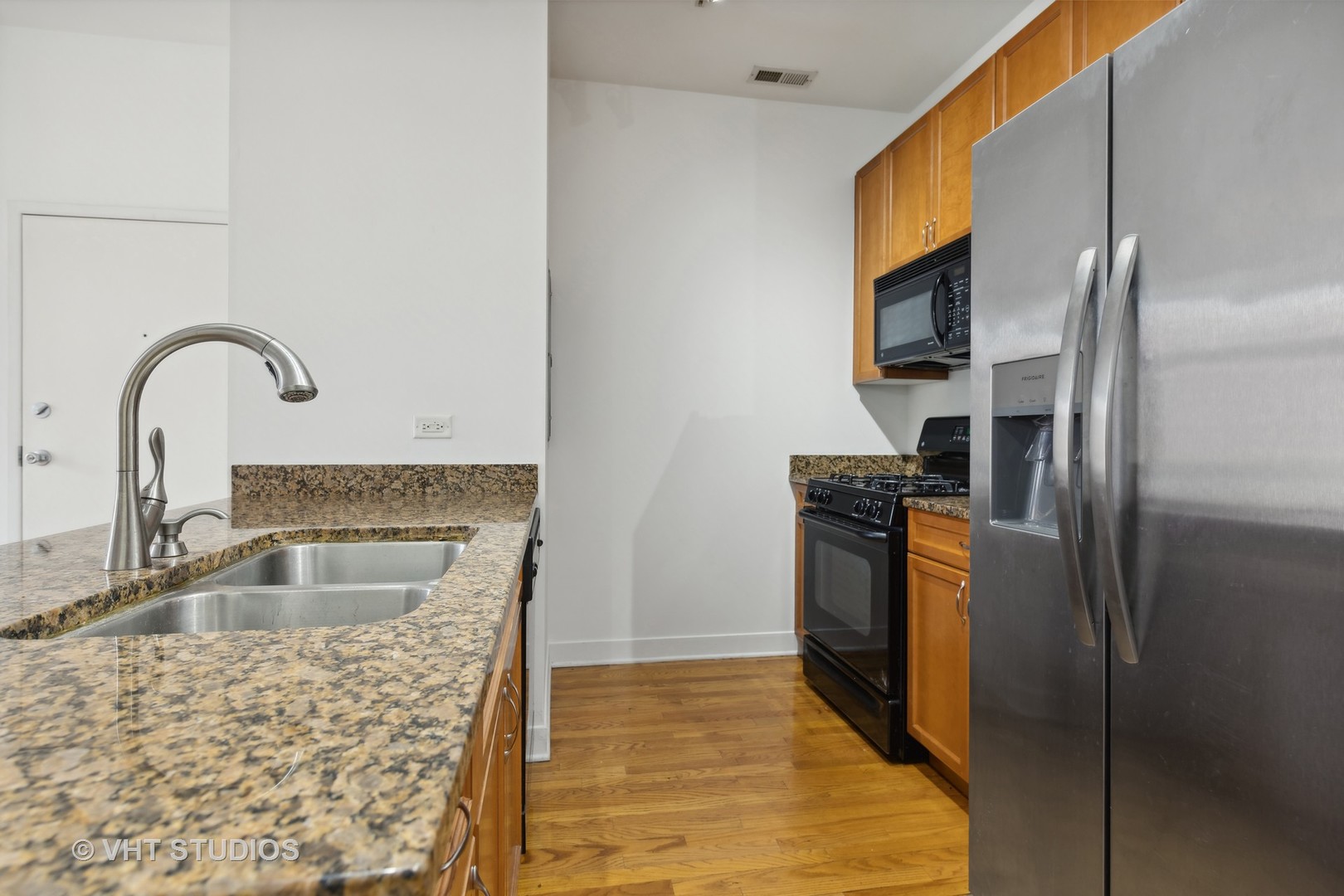 765 West 15th Street, Unit 309 Chicago, IL 60607 - Photo 10 of 14 a kitchen with stainless steel appliances granite countertop a refrigerator a stove and a sink