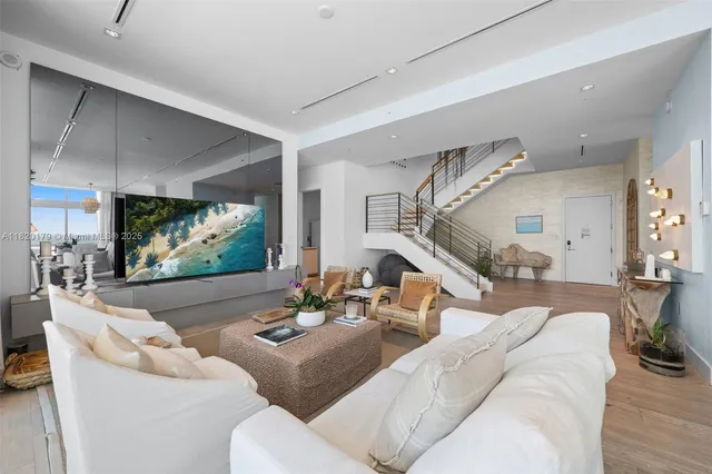 a living room with a bed and a flat screen tv