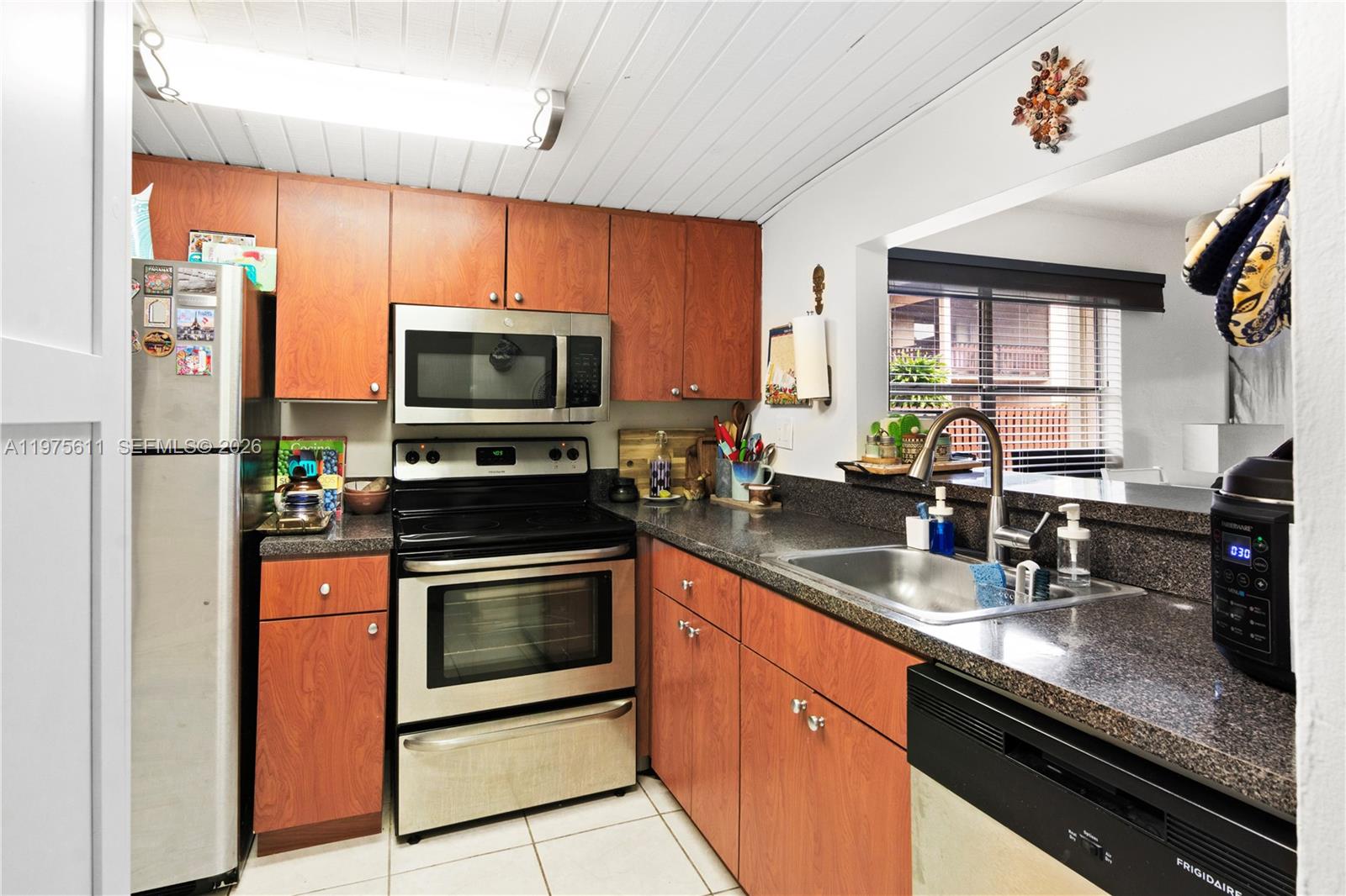 11209 Southwest 88th Street, Unit 101B Miami, FL 33176 - Photo 12 of 28 a kitchen with stainless steel appliances granite countertop a stove a sink and a microwave