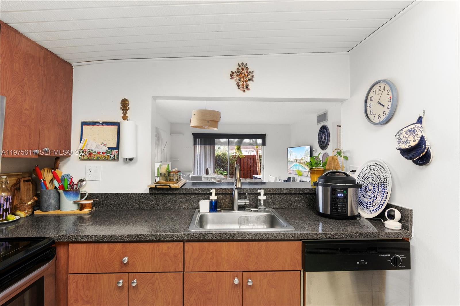 11209 Southwest 88th Street, Unit 101B Miami, FL 33176 - Photo 13 of 28 a kitchen with a sink and a clock on the wall