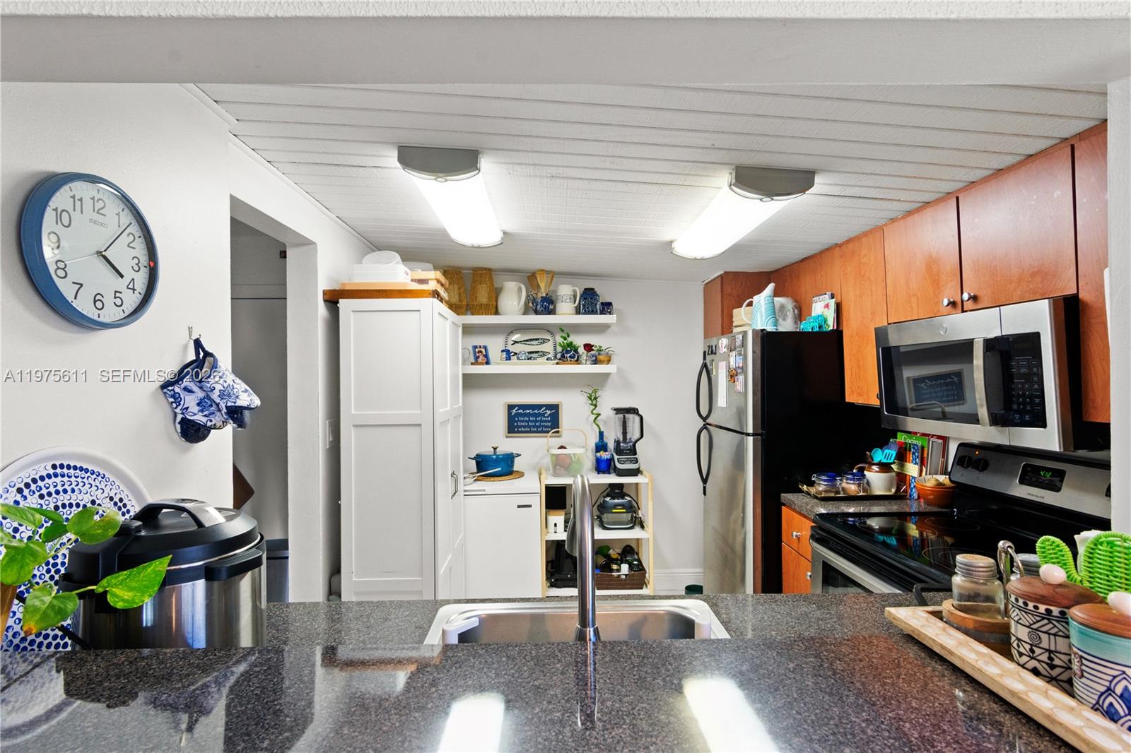 11209 Southwest 88th Street, Unit 101B Miami, FL 33176 - Photo 14 of 28 a view of a kitchen with fridge and workspace