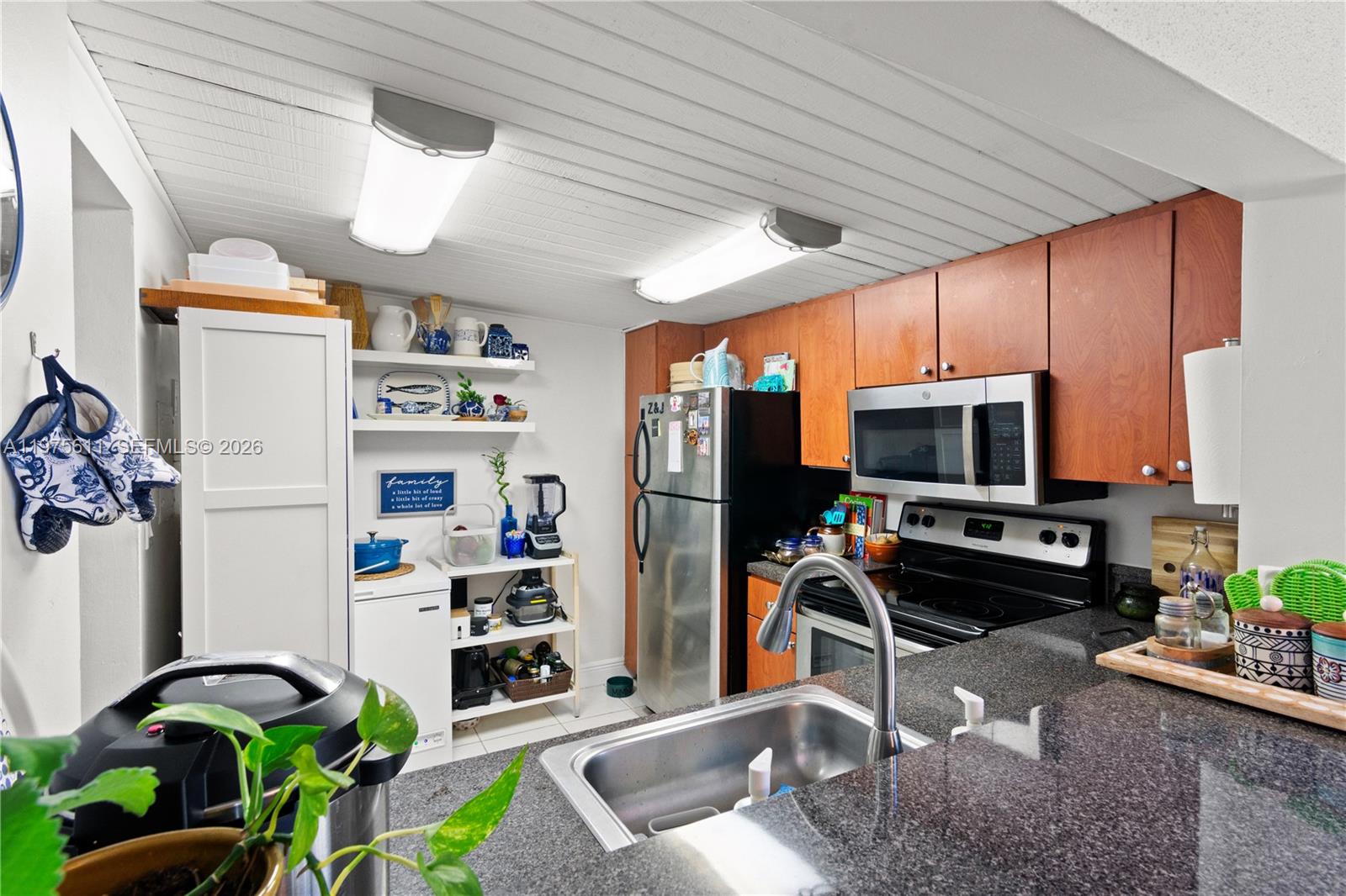 11209 Southwest 88th Street, Unit 101B Miami, FL 33176 - Photo 15 of 28 a work room with furniture a flat screen tv and potted plant