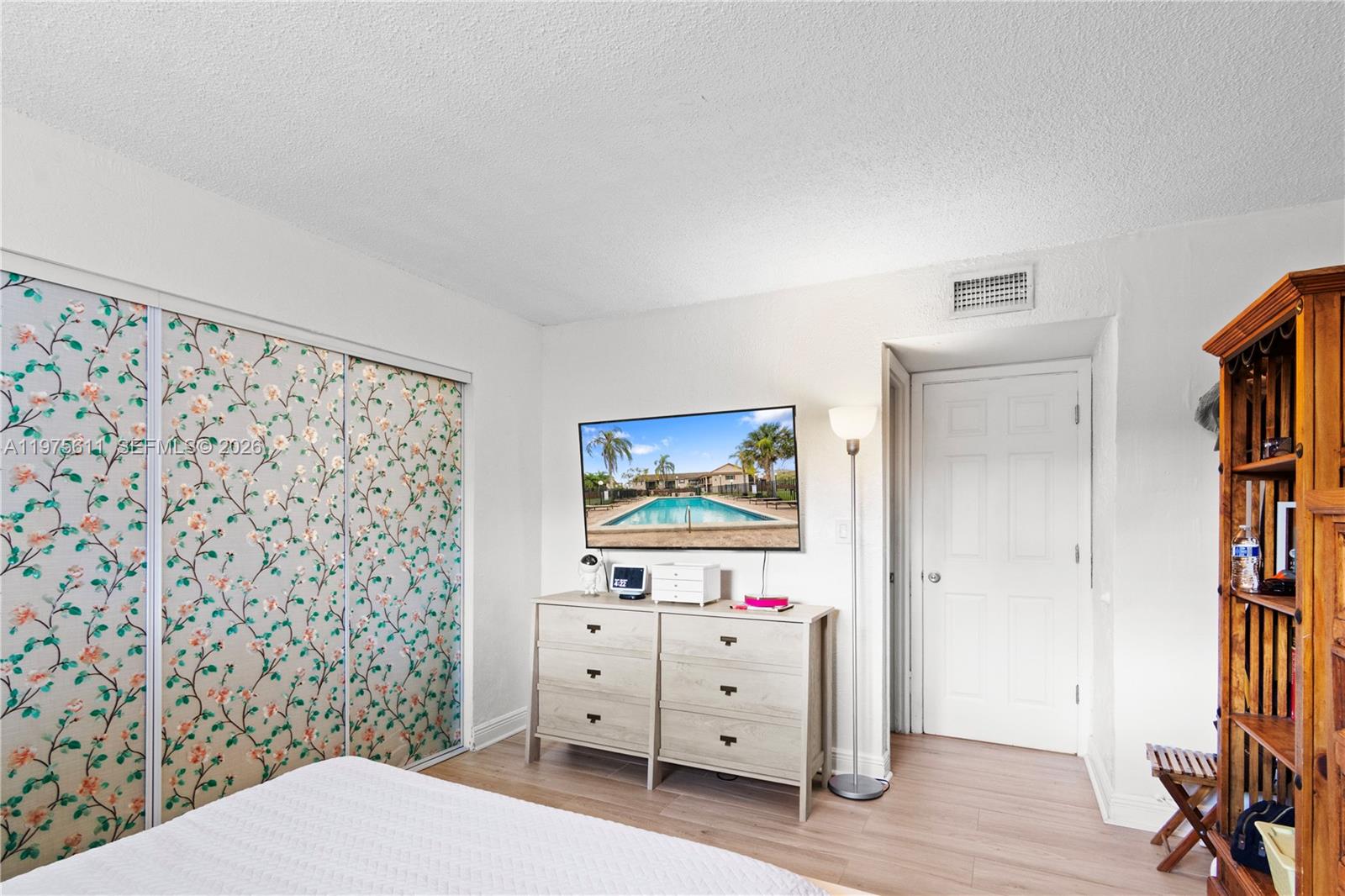 11209 Southwest 88th Street, Unit 101B Miami, FL 33176 - Photo 20 of 28 a bedroom with a bed and a cabinet