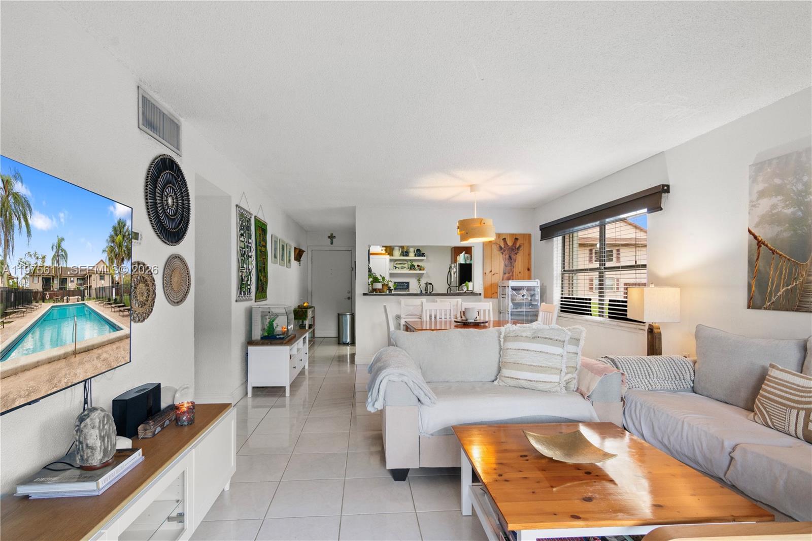 11209 Southwest 88th Street, Unit 101B Miami, FL 33176 - Photo 2 of 28 a living room with furniture and a flat screen tv