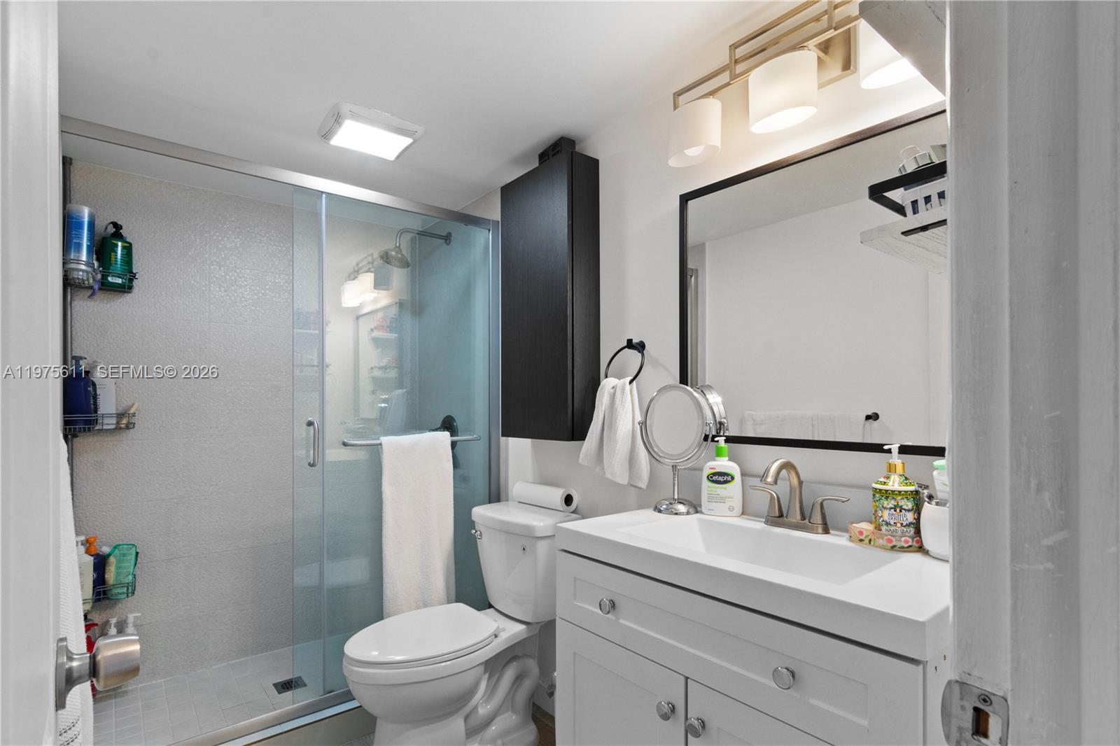 11209 Southwest 88th Street, Unit 101B Miami, FL 33176 - Photo 5 of 28 a bathroom with a toilet sink and mirror