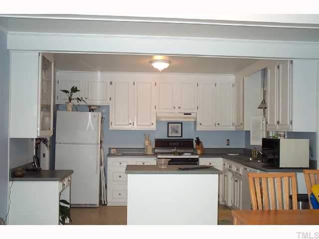 616 Duke Drive Raleigh, NC 27609 - Photo 4 of 8 a kitchen with kitchen island a white cabinets and refrigerator