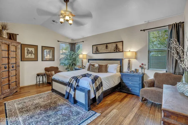 a bedroom with a bed and large windows