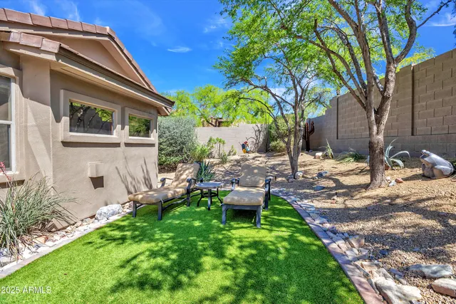 a view of a house with backyard and sitting area