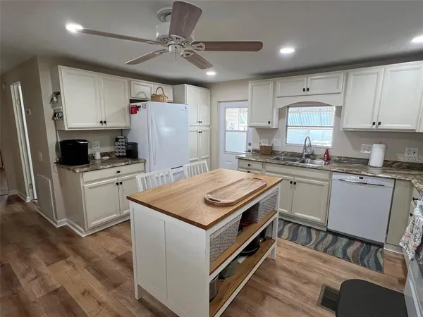a kitchen with a stove a sink a refrigerator and cabinets
