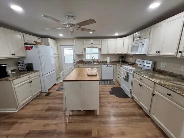 a kitchen with white cabinets and white appliances