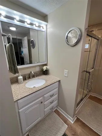a bathroom with a glass door shower and a mirror