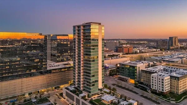 a living room with furniture large windows and wooden floor