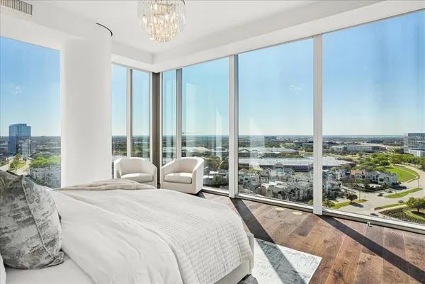 a bedroom with a bed couch and a large window