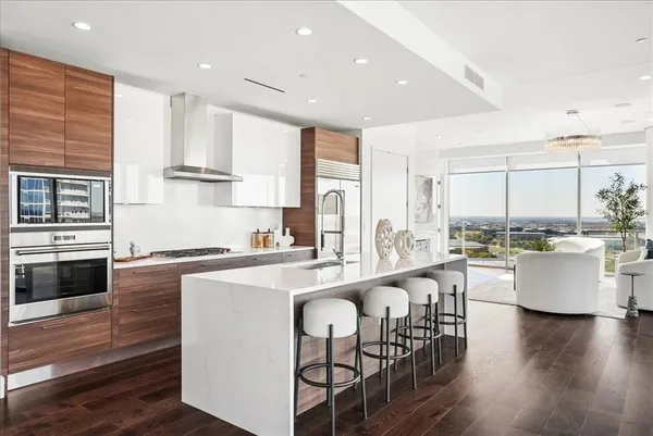 a large white kitchen with wooden floors and kitchen island