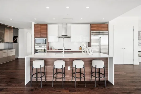 a kitchen with stainless steel appliances granite countertop a sink stove and refrigerator