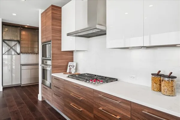 a living room with stainless steel appliances granite countertop furniture wooden floor and a large window