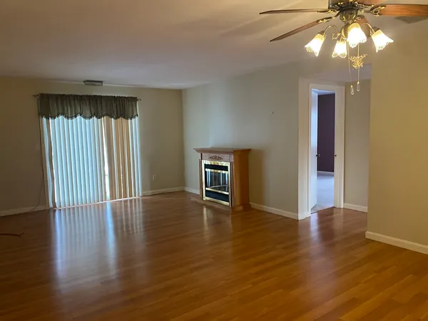 an empty room with wooden floor and a window