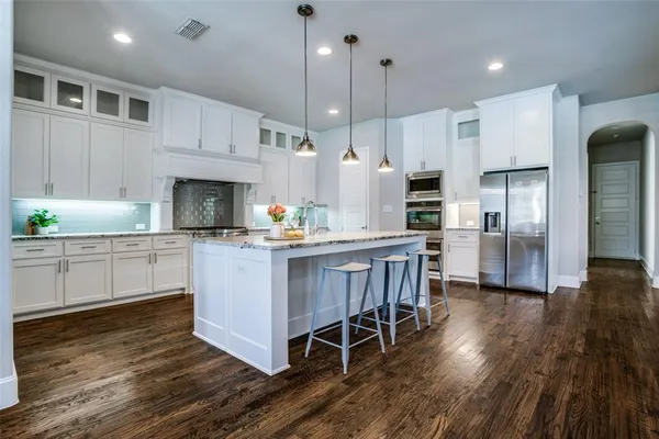 a kitchen with kitchen island granite countertop a sink a counter top space appliances and cabinets