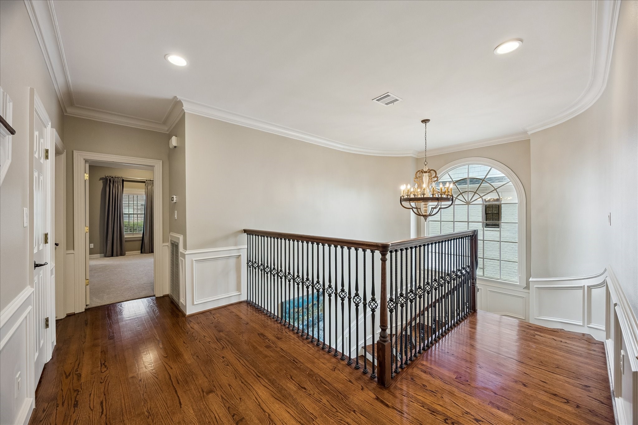 6358 Auden Street Houston, TX 77005 - Photo 20 of 50 a view of a hallway with wooden floor and chandelier