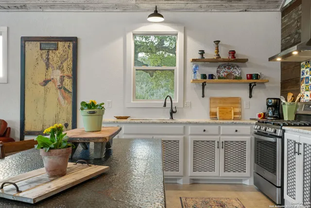 a kitchen with granite countertop a sink and a stove