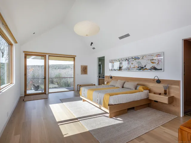 a bedroom with a bed and a large window