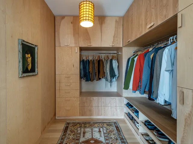 a view of walk in closet with clothes and shoes