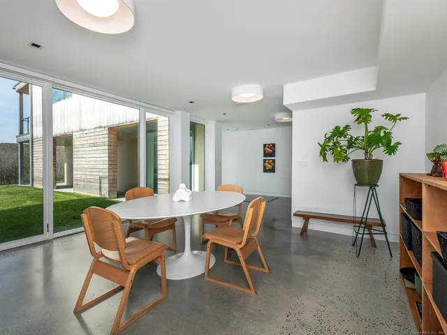 a dining room with furniture and a floor to ceiling window