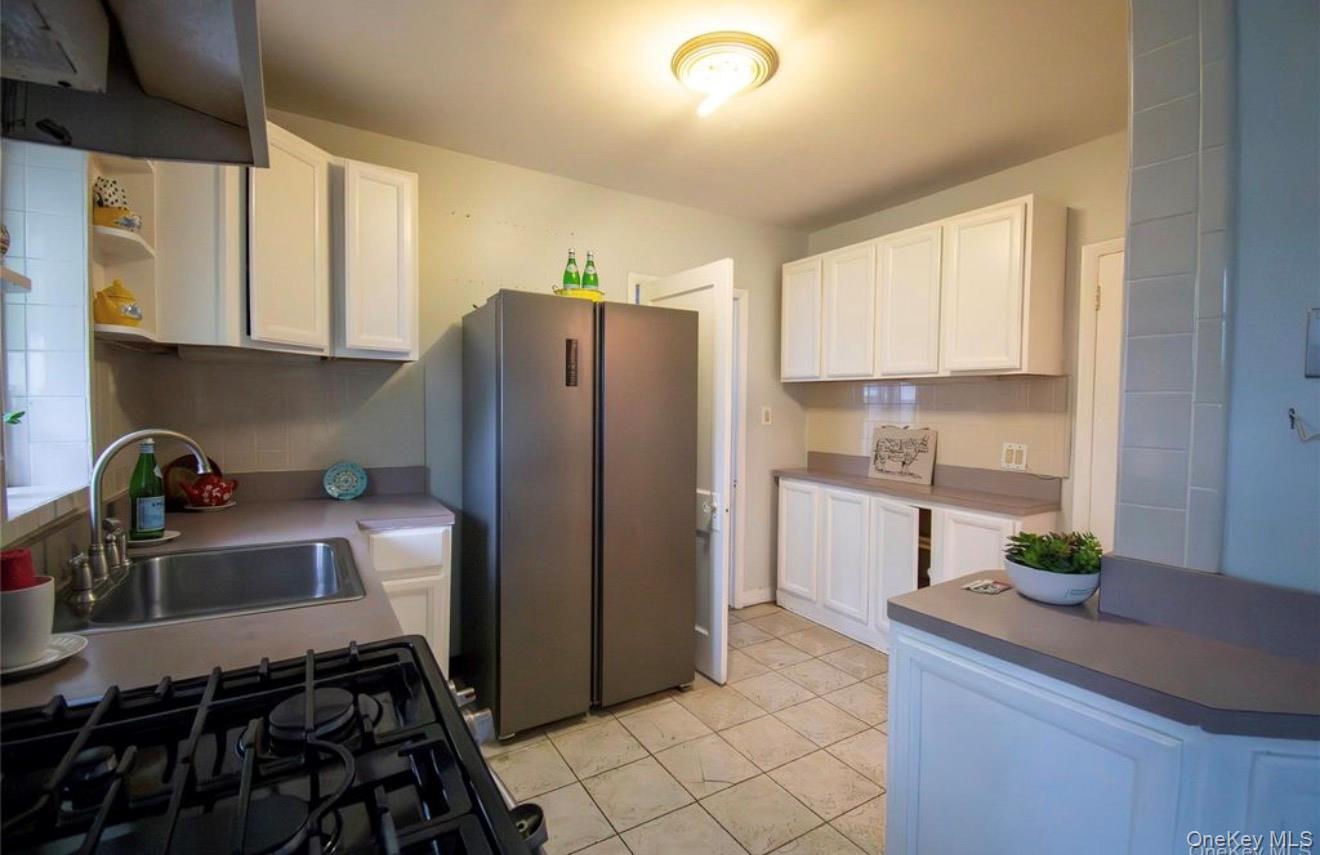 76 Henry Street Roosevelt, NY 11575 - Photo 9 of 14 a kitchen with stainless steel appliances granite countertop a refrigerator and a sink