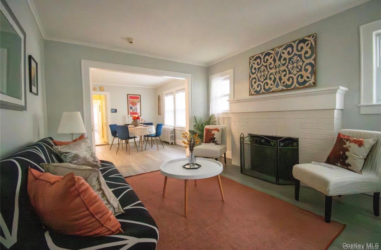 76 Henry Street Roosevelt, NY 11575 - Photo 13 of 14 a living room with furniture a fireplace and a potted plant