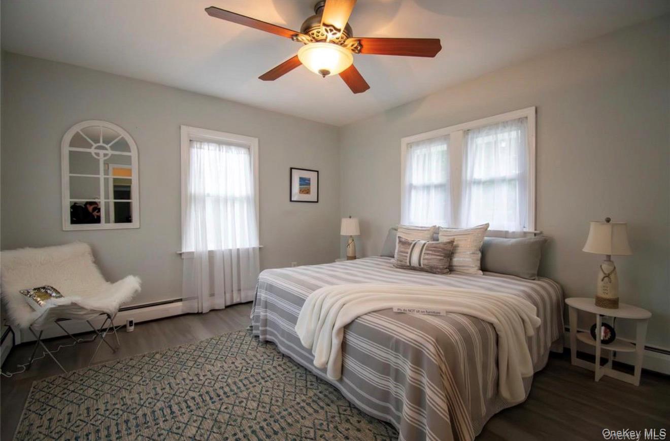 76 Henry Street Roosevelt, NY 11575 - Photo 5 of 14 a bedroom with a bed wooden floor and window