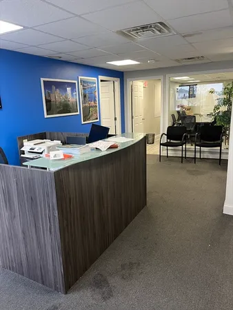 a view of a workspace with furniture and a window