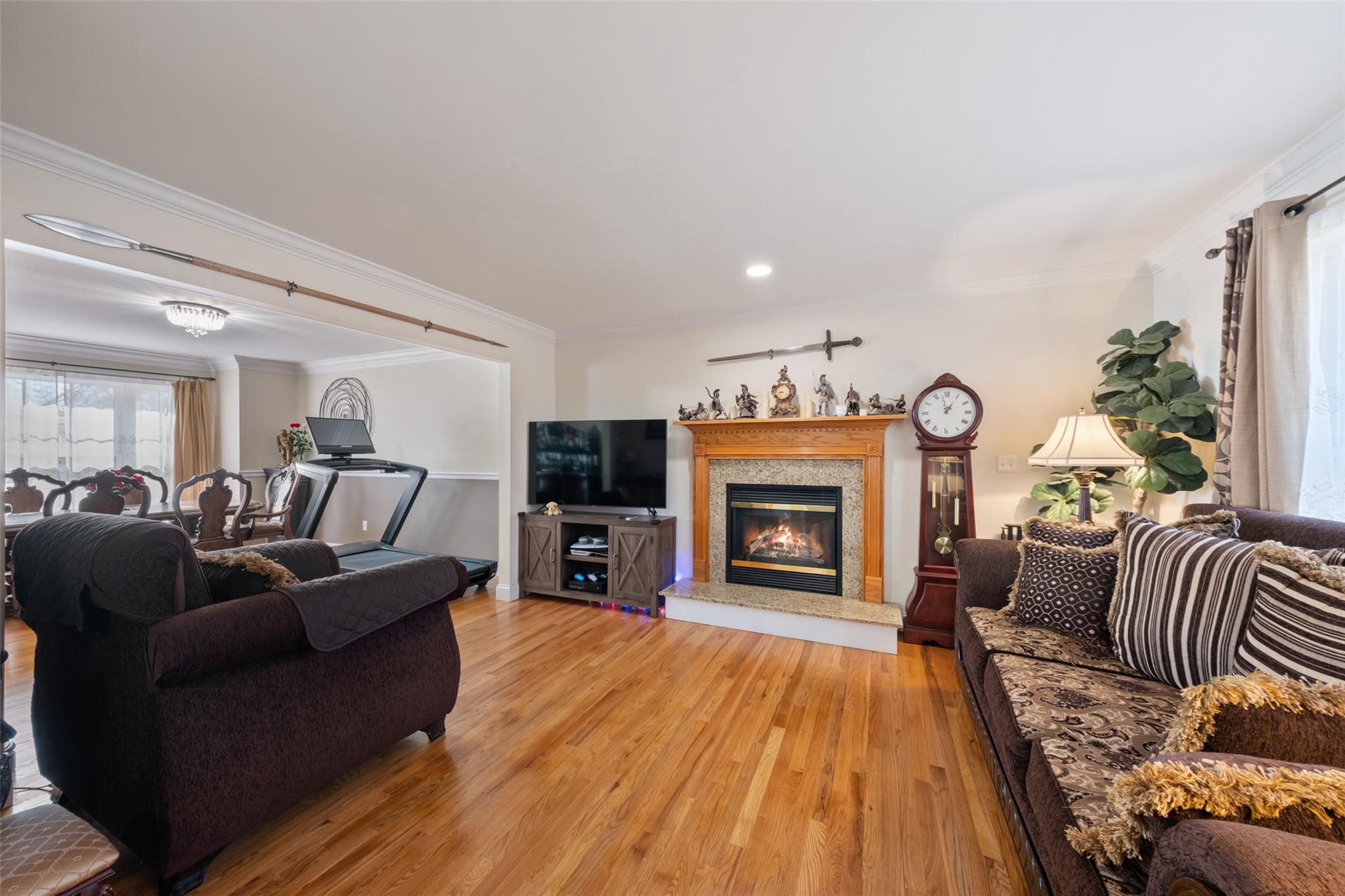 15 Bobrick Road Poughkeepsie, NY 12601 - Photo 12 of 36 Living room featuring light wood-style flooring, crown molding, and a glass covered fireplace