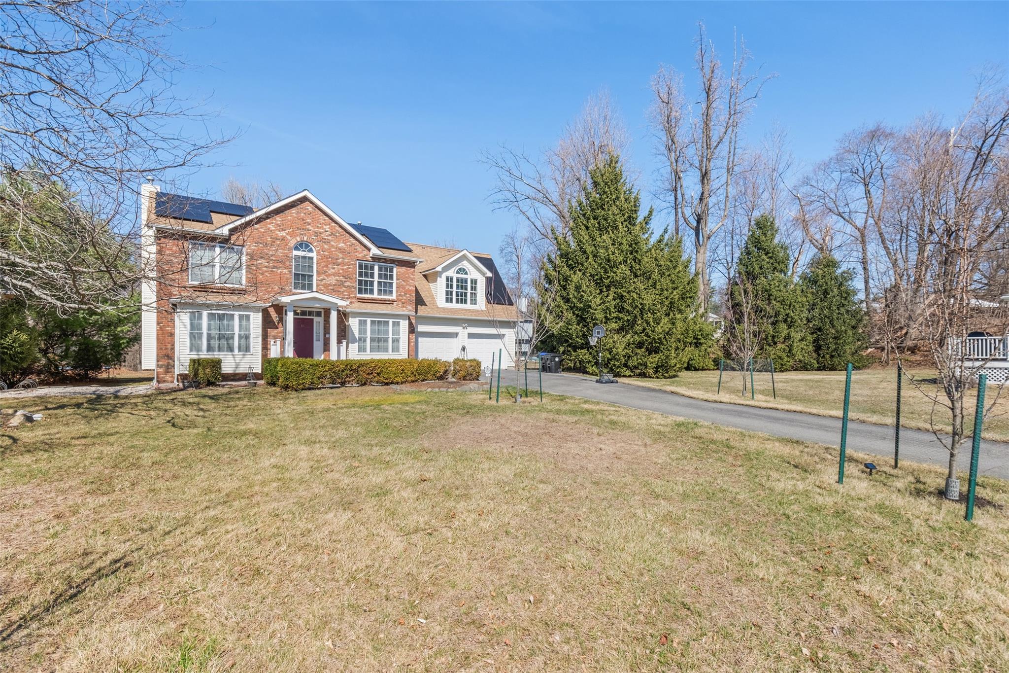15 Bobrick Road Poughkeepsie, NY 12601 - Photo 2 of 36 View of front of home featuring aphalt driveway, brick siding, solar panels, a front yard, and a garage