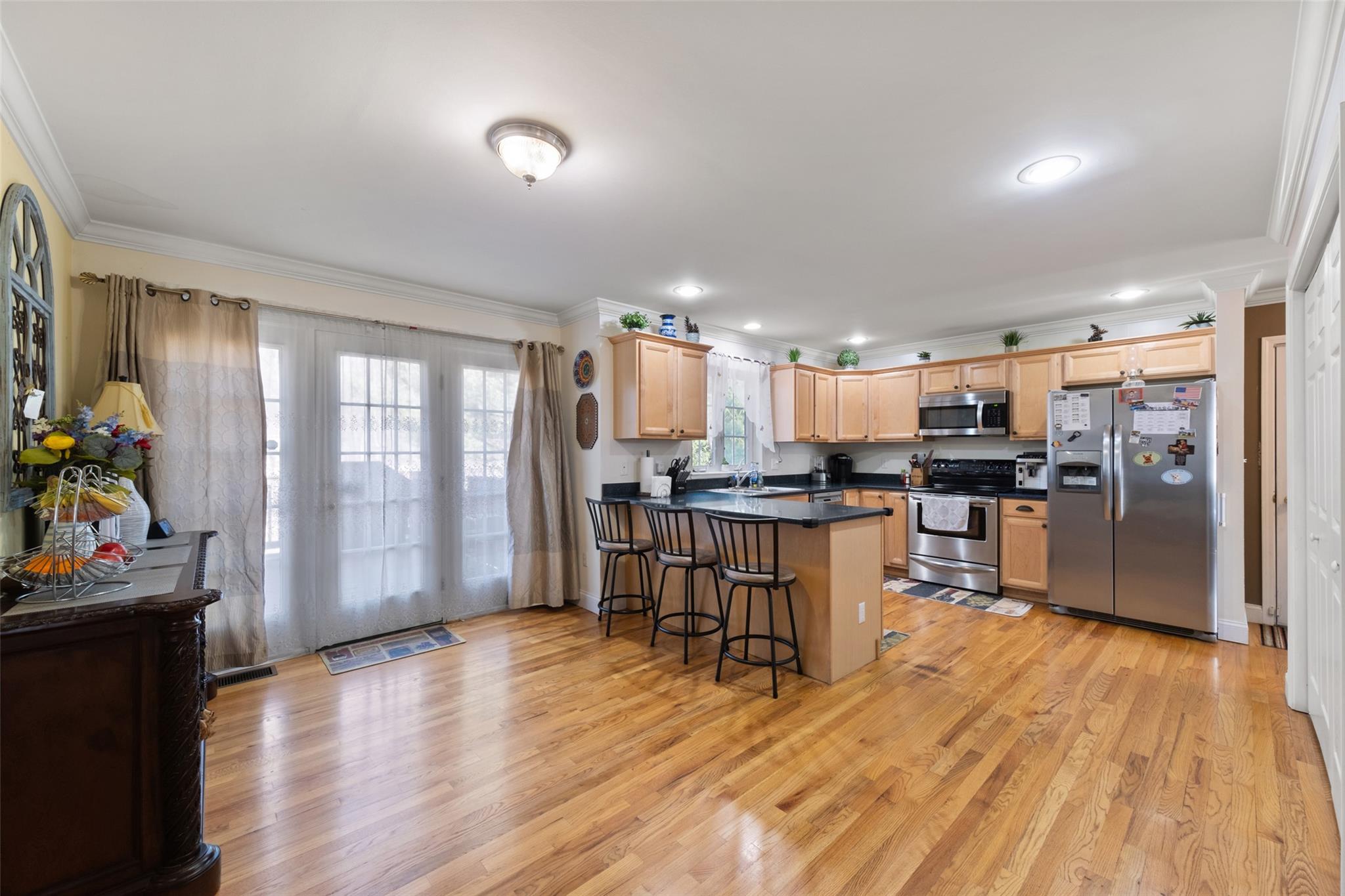 15 Bobrick Road Poughkeepsie, NY 12601 - Photo 3 of 36 Kitchen featuring crown molding, light wood-style flooring, a peninsula, appliances with stainless steel finishes, and light brown cabinets