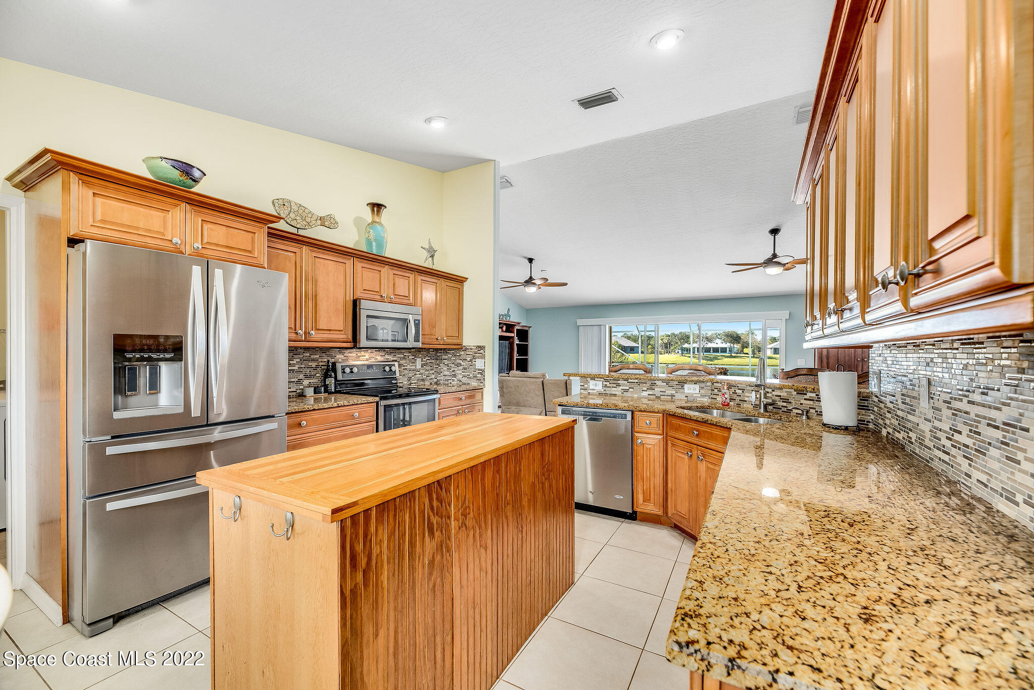 1566 Eagles Circle Sebastian, FL 32958 - Photo 17 of 59 a kitchen with stainless steel appliances kitchen island granite countertop a refrigerator and a stove top oven