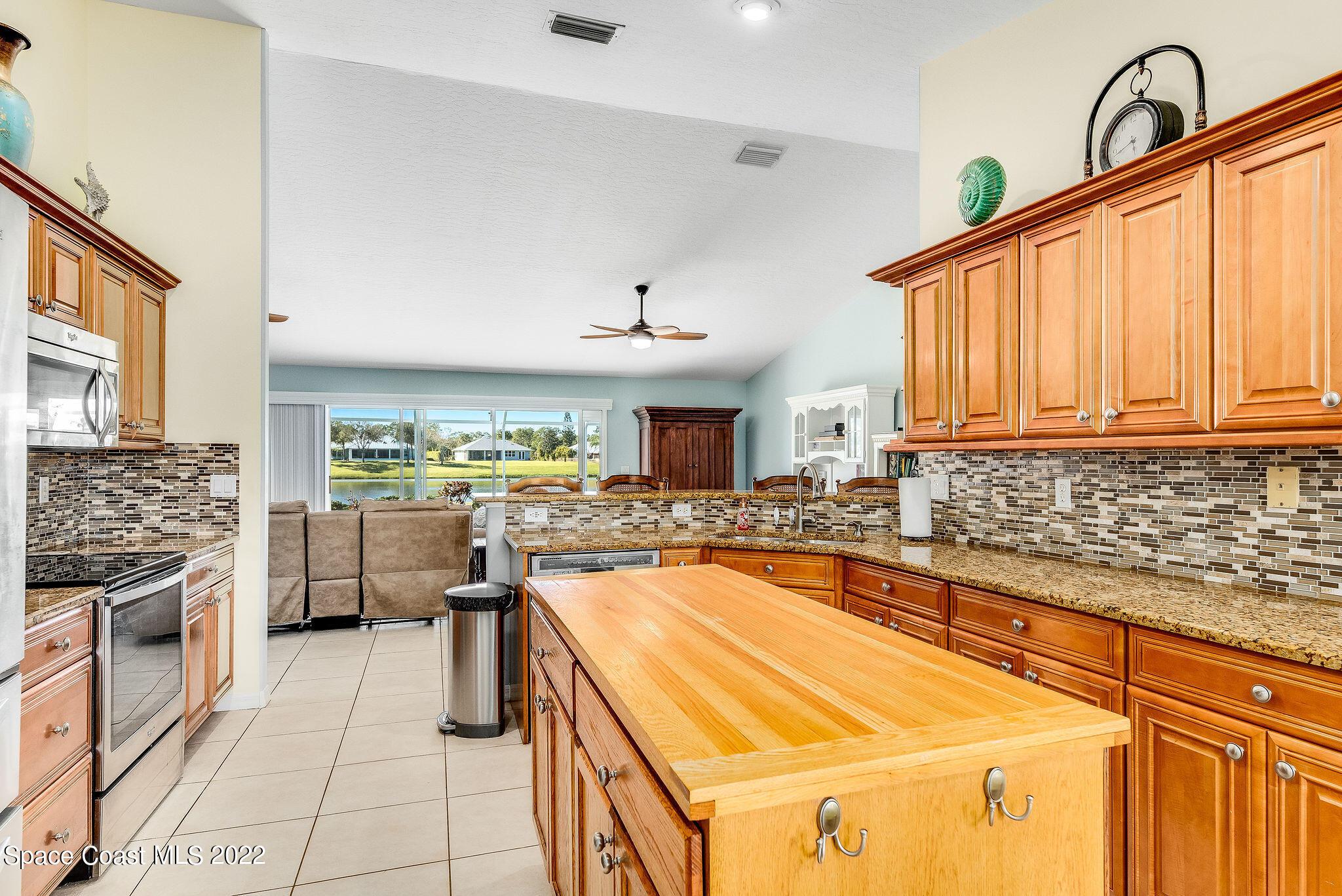 1566 Eagles Circle Sebastian, FL 32958 - Photo 18 of 59 a kitchen with kitchen island a sink stove and cabinets